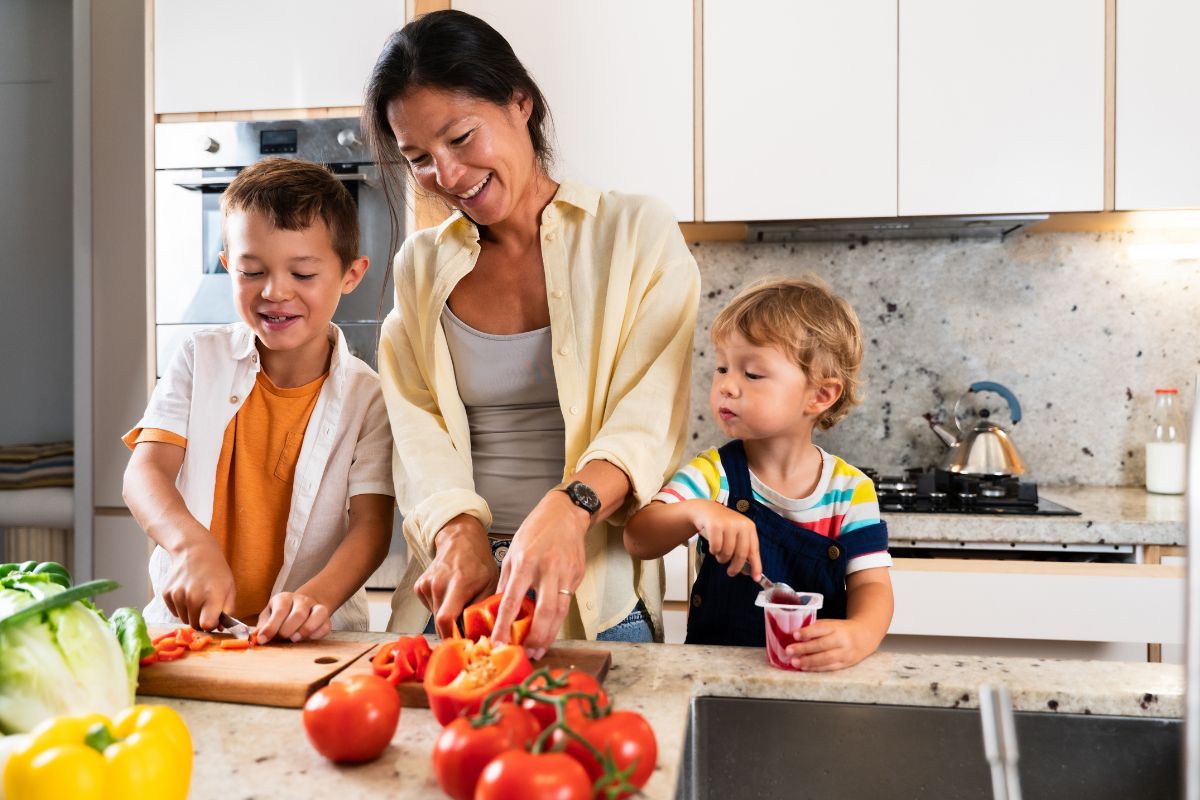 Mom and kids preparing food in the kitchen.